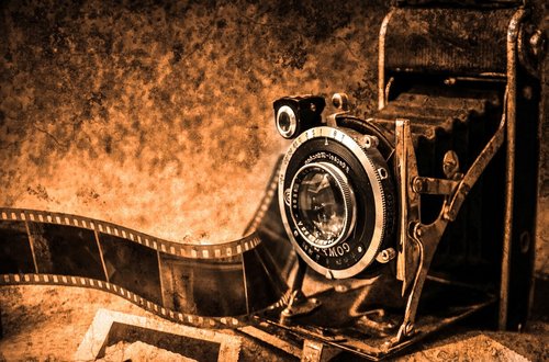 Eine alte Kamera mit einem Super 8 Film im Hintergrund